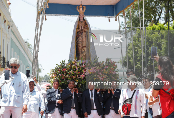 People are carrying the Virgen de Ocotlan while walking on a sawdust carpet during the traditional downing of the Virgen de Ocotlan. In this...