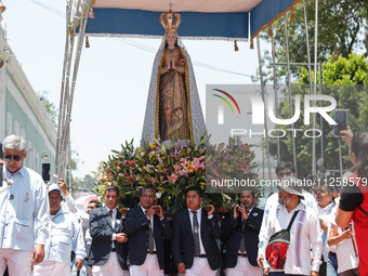 People are carrying the Virgen de Ocotlan while walking on a sawdust carpet during the traditional downing of the Virgen de Ocotlan. In this...