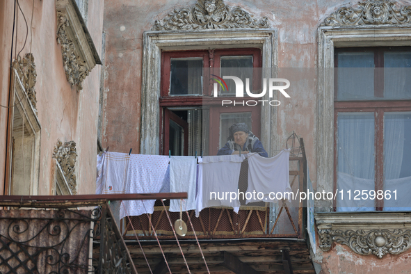 An elderly woman is standing on the balcony in a courtyard in the historic city center in Odesa, Ukraine, on May 20, 2024. NO USE RUSSIA. NO...