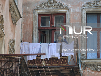 An elderly woman is standing on the balcony in a courtyard in the historic city center in Odesa, Ukraine, on May 20, 2024. NO USE RUSSIA. NO...