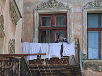 An elderly woman is standing on the balcony in a courtyard in the historic city center in Odesa, Ukraine, on May 20, 2024. NO USE RUSSIA. NO...