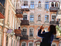 A woman is taking pictures of a courtyard in the historic city center in Odesa, Ukraine, on May 20, 2024. NO USE RUSSIA. NO USE BELARUS. (