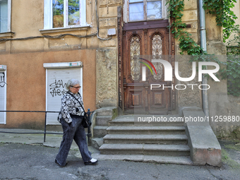 A woman is being seen in a courtyard in the historic city center in Odesa, Ukraine, on May 20, 2024. NO USE RUSSIA. NO USE BELARUS. (