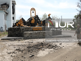 A soldier is standing by the monument to the warriors of the Soviet-Afghan War outside the Palace of Culture destroyed by Russian shelling o...