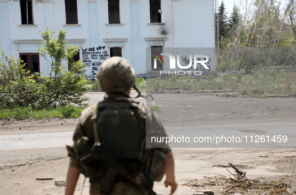 A soldier is facing the Palace of Culture destroyed by Russian shelling on July 23, 2023, in Chasiv Yar, Donetsk region, eastern Ukraine, on...