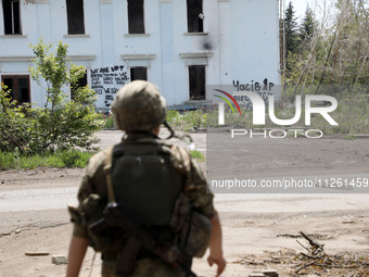 A soldier is facing the Palace of Culture destroyed by Russian shelling on July 23, 2023, in Chasiv Yar, Donetsk region, eastern Ukraine, on...