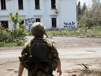 A soldier is facing the Palace of Culture destroyed by Russian shelling on July 23, 2023, in Chasiv Yar, Donetsk region, eastern Ukraine, on...