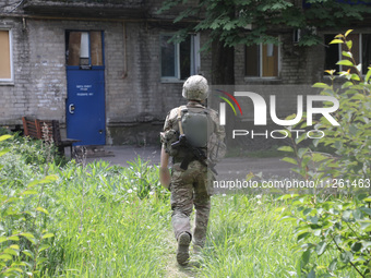 A soldier is walking towards an apartment block damaged by Russian shelling in Chasiv Yar, Ukraine, on May 18, 2024. NO USE RUSSIA. NO USE B...