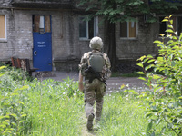 A soldier is walking towards an apartment block damaged by Russian shelling in Chasiv Yar, Ukraine, on May 18, 2024. NO USE RUSSIA. NO USE B...