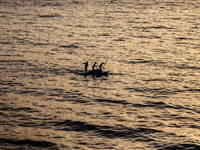 Palestinians are walking amidst tents housing internally displaced people, along the coastline in Deir el-Balah in the central Gaza Strip, o...