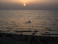 Palestinians are walking amidst tents housing internally displaced people, along the coastline in Deir el-Balah in the central Gaza Strip, o...