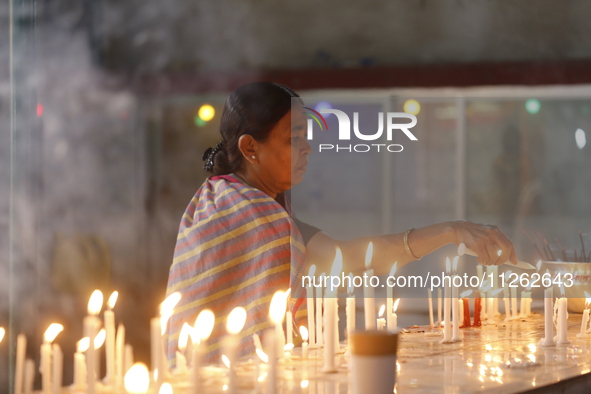 A Buddhist woman is lighting a candle at a temple on the occasion of the Buddha Purnima festival, which marks the birth of Gautam Buddha, in...