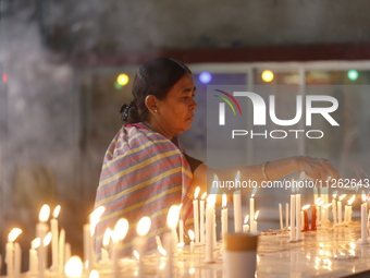 A Buddhist woman is lighting a candle at a temple on the occasion of the Buddha Purnima festival, which marks the birth of Gautam Buddha, in...