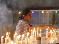 A Buddhist woman is lighting a candle at a temple on the occasion of the Buddha Purnima festival, which marks the birth of Gautam Buddha, in...