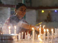 A Buddhist woman is lighting a candle at a temple on the occasion of the Buddha Purnima festival, which marks the birth of Gautam Buddha, in...