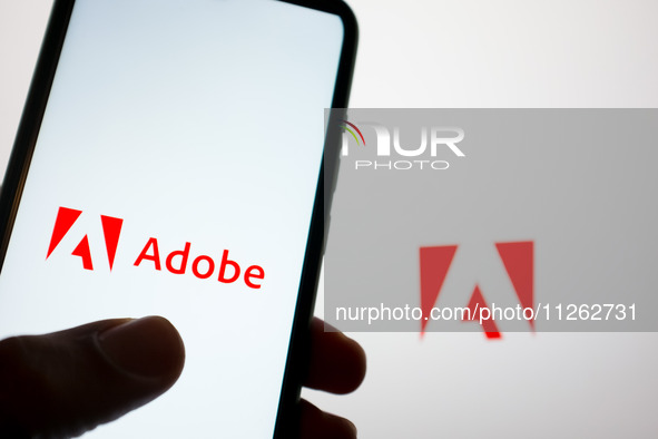 The Adobe logo is being displayed on a smartphone screen and on a computer screen in Athens, Greece, on May 22, 2024. 