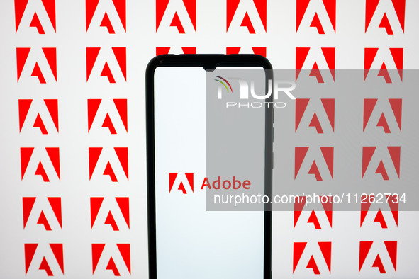 The Adobe logos are being displayed on a smartphone screen and on a computer screen in Athens, Greece, on May 22, 2024. 