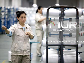 A worker is producing textile chemical fiber products on a production line in Fuzhou, China, on May 22, 2024. (