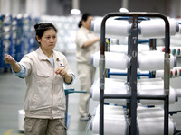 A worker is producing textile chemical fiber products on a production line in Fuzhou, China, on May 22, 2024. (