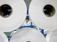 A worker is producing textile chemical fiber products on a production line in Fuzhou, China, on May 22, 2024. (