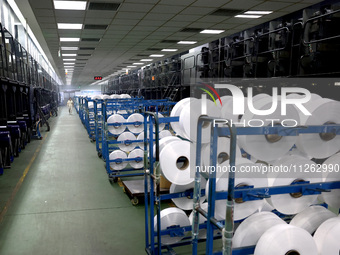 A worker is producing textile chemical fiber products on a production line in Fuzhou, China, on May 22, 2024. (