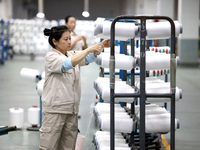 A worker is producing textile chemical fiber products on a production line in Fuzhou, China, on May 22, 2024. (