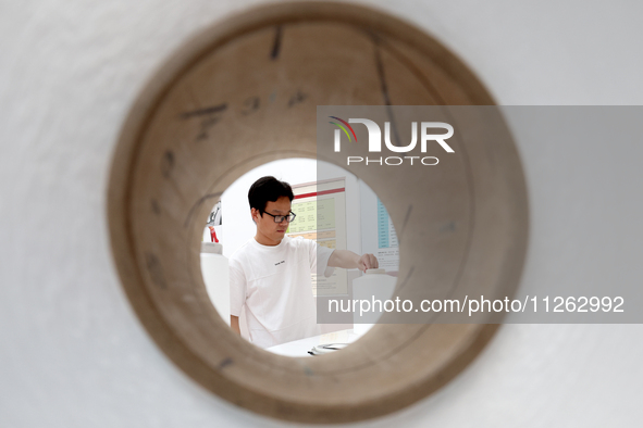 A staff member is arranging products at an exhibition hall in Fuzhou, China, on May 22, 2024. 