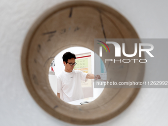 A staff member is arranging products at an exhibition hall in Fuzhou, China, on May 22, 2024. (