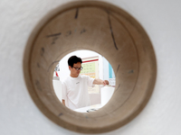 A staff member is arranging products at an exhibition hall in Fuzhou, China, on May 22, 2024. (