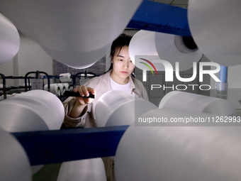 A worker is producing textile chemical fiber products on a production line in Fuzhou, China, on May 22, 2024. (