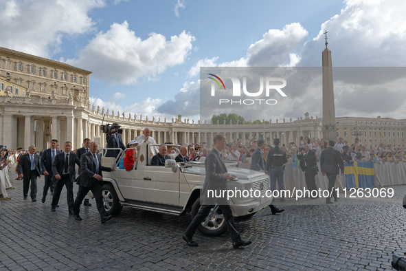 Pope Francis is waving to the crowd during his weekly general audience in Vatican City, on May 22, 2024. 