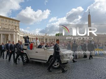 Pope Francis is waving to the crowd during his weekly general audience in Vatican City, on May 22, 2024. (