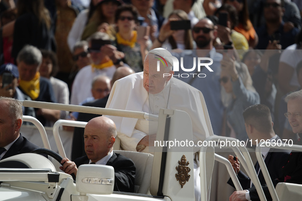 Pope Francis is waving to the crowd during his weekly general audience in Vatican City, on May 22, 2024. 