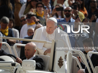 Pope Francis is waving to the crowd during his weekly general audience in Vatican City, on May 22, 2024. (