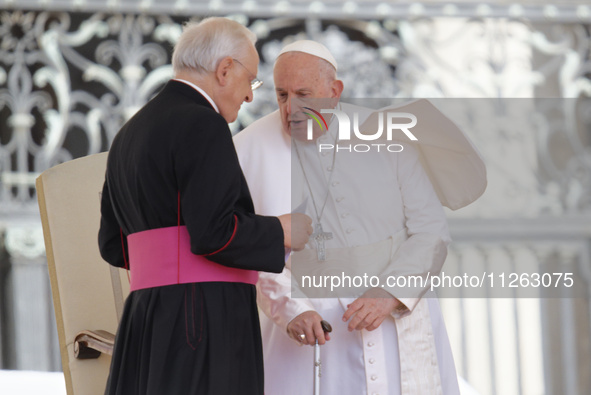 Pope Francis is talking with Monsignor Leonardo Sappienza at the end of his weekly general audience in Vatican City, on May 22, 2024 