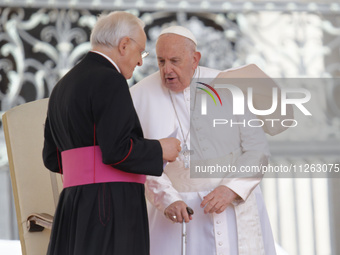 Pope Francis is talking with Monsignor Leonardo Sappienza at the end of his weekly general audience in Vatican City, on May 22, 2024 (