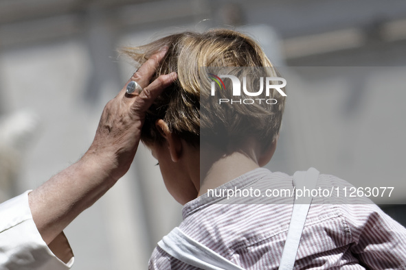 Pope Francis is waving to a child at the end of his weekly general audience in St. Peter's Square, at the Vatican, on May 22, 2024. 