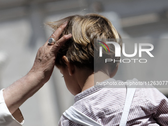 Pope Francis is waving to a child at the end of his weekly general audience in St. Peter's Square, at the Vatican, on May 22, 2024. (