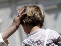 Pope Francis is waving to a child at the end of his weekly general audience in St. Peter's Square, at the Vatican, on May 22, 2024. (