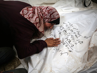 A displaced Palestinian mother is showering her child amid a heat wave inside a tent at a temporary camp in Deir el-Balah in the central Gaz...