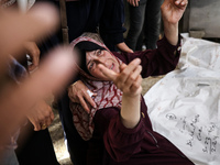 A displaced Palestinian mother is showering her child amid a heat wave inside a tent at a temporary camp in Deir el-Balah in the central Gaz...