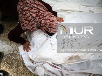 A displaced Palestinian mother is showering her child amid a heat wave inside a tent at a temporary camp in Deir el-Balah in the central Gaz...