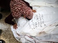 A displaced Palestinian mother is showering her child amid a heat wave inside a tent at a temporary camp in Deir el-Balah in the central Gaz...