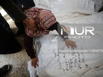 A displaced Palestinian mother is showering her child amid a heat wave inside a tent at a temporary camp in Deir el-Balah in the central Gaz...