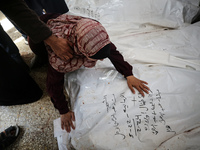 A displaced Palestinian mother is showering her child amid a heat wave inside a tent at a temporary camp in Deir el-Balah in the central Gaz...