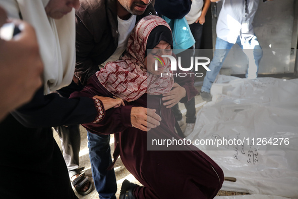 A displaced Palestinian mother is showering her child amid a heat wave inside a tent at a temporary camp in Deir el-Balah in the central Gaz...