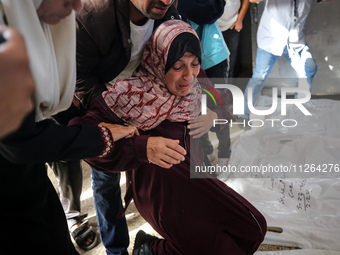 A displaced Palestinian mother is showering her child amid a heat wave inside a tent at a temporary camp in Deir el-Balah in the central Gaz...