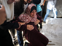 A displaced Palestinian mother is showering her child amid a heat wave inside a tent at a temporary camp in Deir el-Balah in the central Gaz...