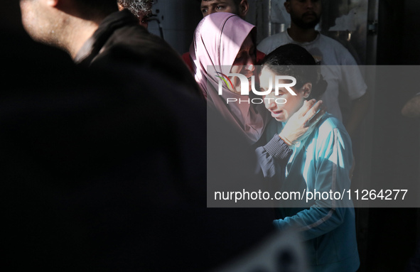 A displaced Palestinian mother is showering her child amid a heat wave inside a tent at a temporary camp in Deir el-Balah in the central Gaz...