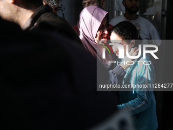 A displaced Palestinian mother is showering her child amid a heat wave inside a tent at a temporary camp in Deir el-Balah in the central Gaz...